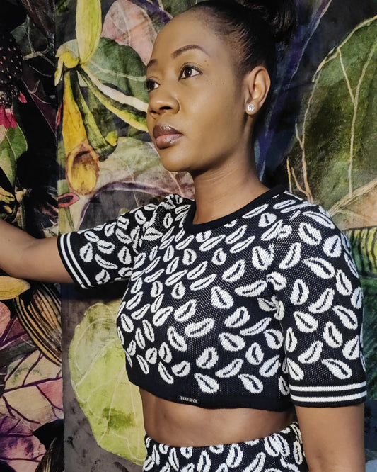 Woman wearing a black and white patterned outfit against a colorful floral background