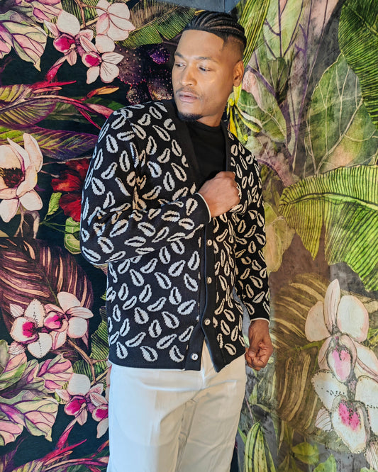 Person wearing a black and white patterned jacket against a colorful floral background